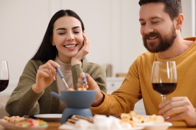 Photo of Affectionate couple enjoying fondue during romantic date at home