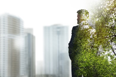 Double exposure of businessman and green leaves in city