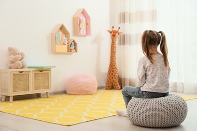 Photo of Lonely little girl at home, back view. Autism concept