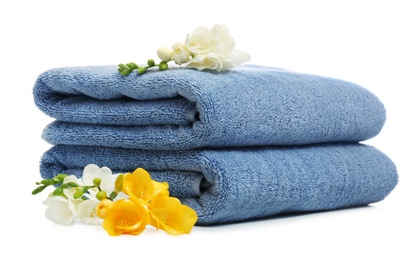 Clean folded towels with flowers on white background