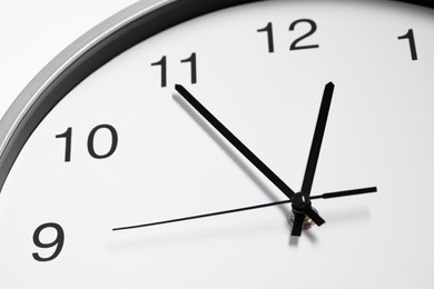 Stylish round clock on white background, closeup. Interior element