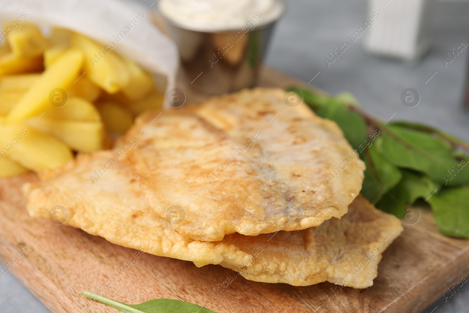 Photo of Delicious fish and chips with mangold on table, closeup
