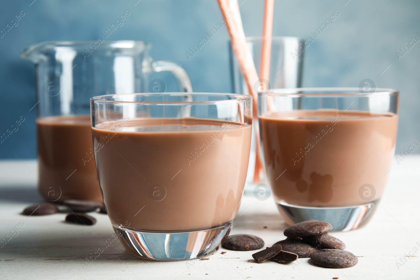 Photo of Glasses of tasty chocolate milk on wooden table. Dairy drink