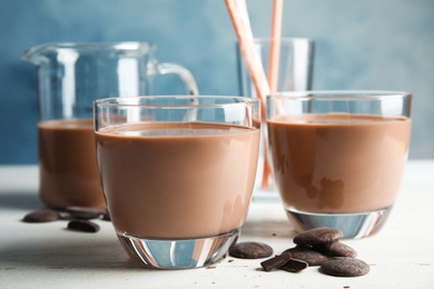 Glasses of tasty chocolate milk on wooden table. Dairy drink