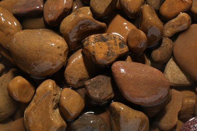 Photo of Beautiful pebbles in water as background, top view