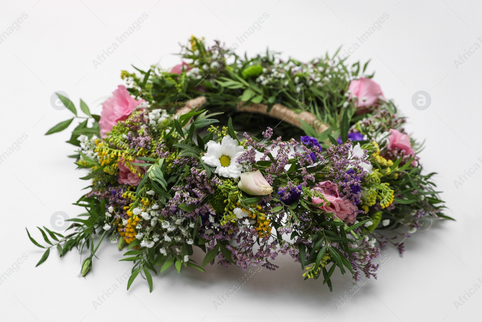 Photo of Wreath made of beautiful flowers on white background, closeup