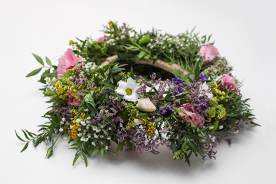 Wreath made of beautiful flowers on white background, closeup