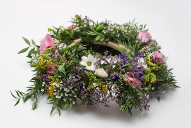 Photo of Wreath made of beautiful flowers on white background, closeup