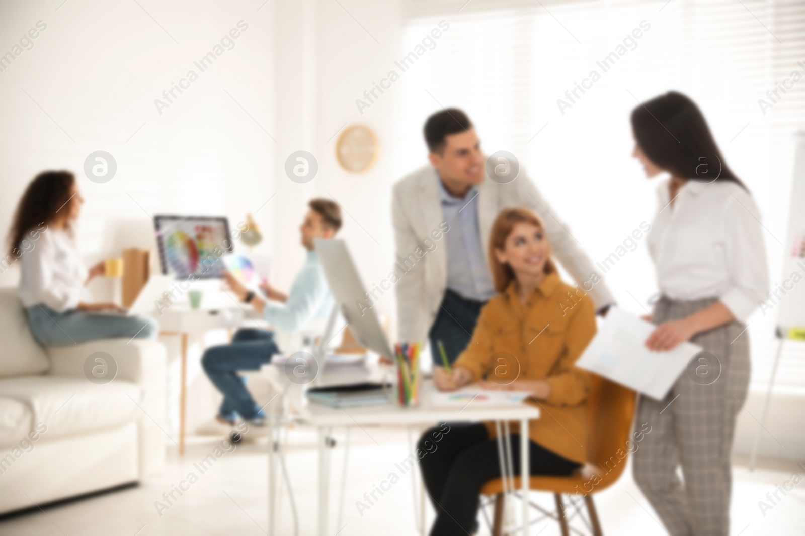 Image of Blurred view of professional interior designers working in office