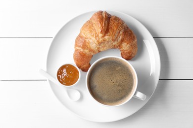 Photo of Fresh croissant, jam and coffee on white wooden table, top view. Tasty breakfast