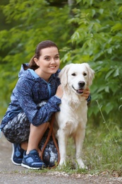 Photo of Young woman with her dog together in park. Pet care
