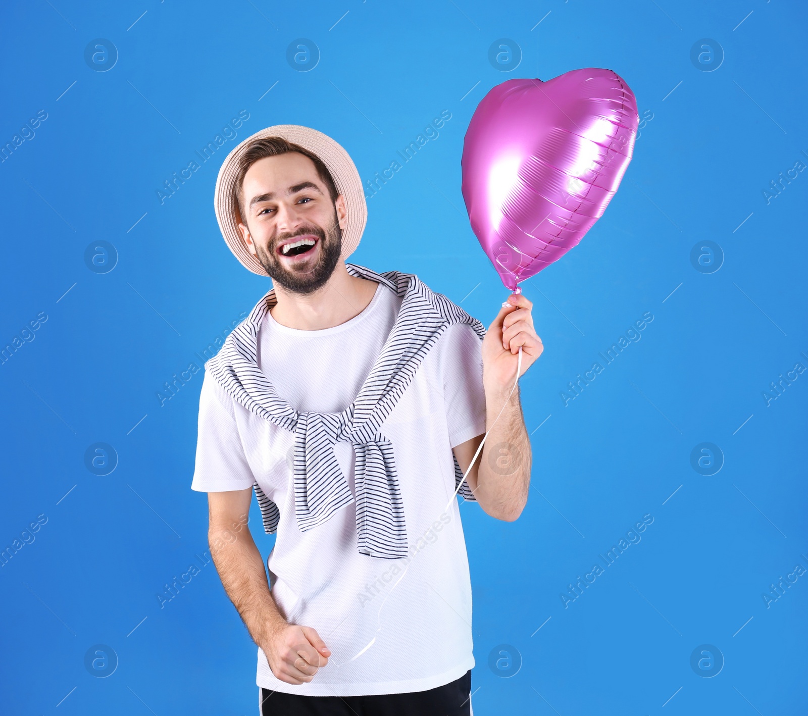 Photo of Portrait of young man with heart shaped balloon on color background