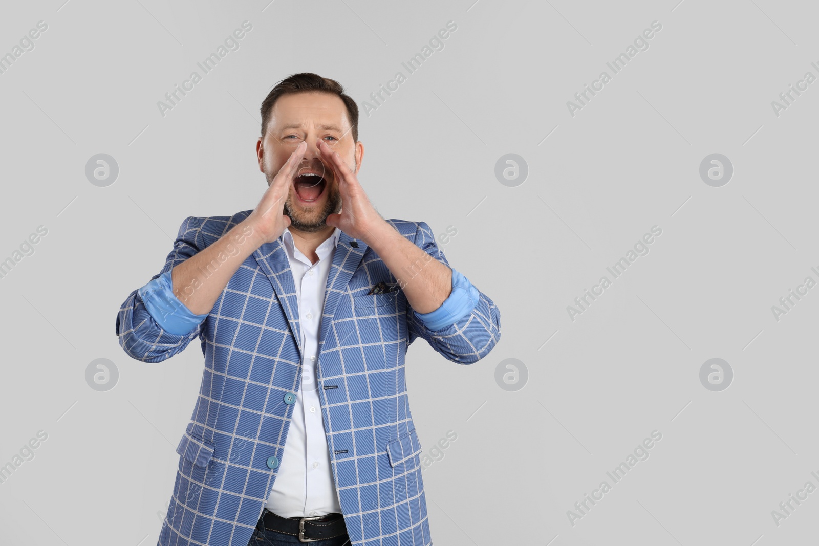 Photo of Portrait of screaming mature man on light grey background