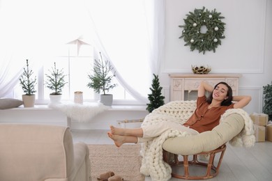 Photo of Woman resting in comfortable papasan chair at home