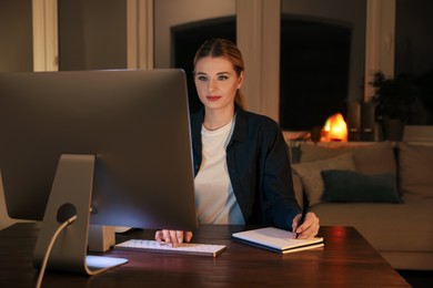 Home workplace. Woman working on computer at wooden desk in room