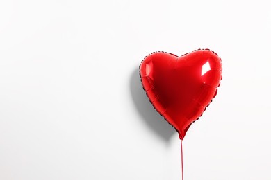 Photo of Red heart shaped balloon on white background, space for text