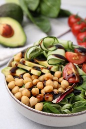 Delicious salad with chickpeas, vegetables and balsamic vinegar on white table, closeup