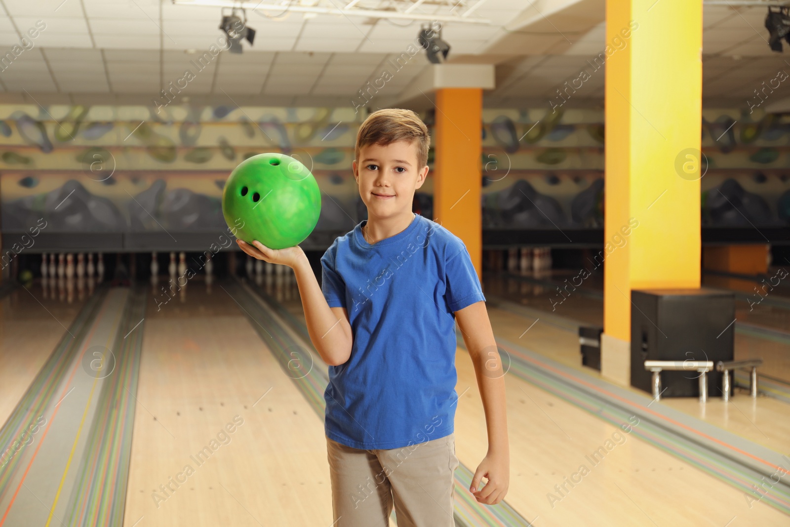 Photo of Preteen boy with ball in bowling club