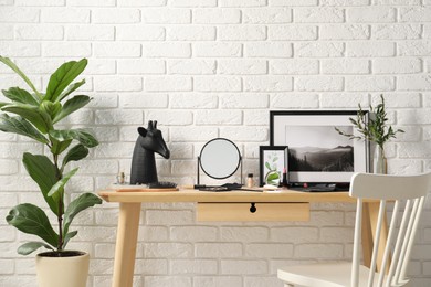 Photo of Dressing table with mirror, makeup products and accessories in room