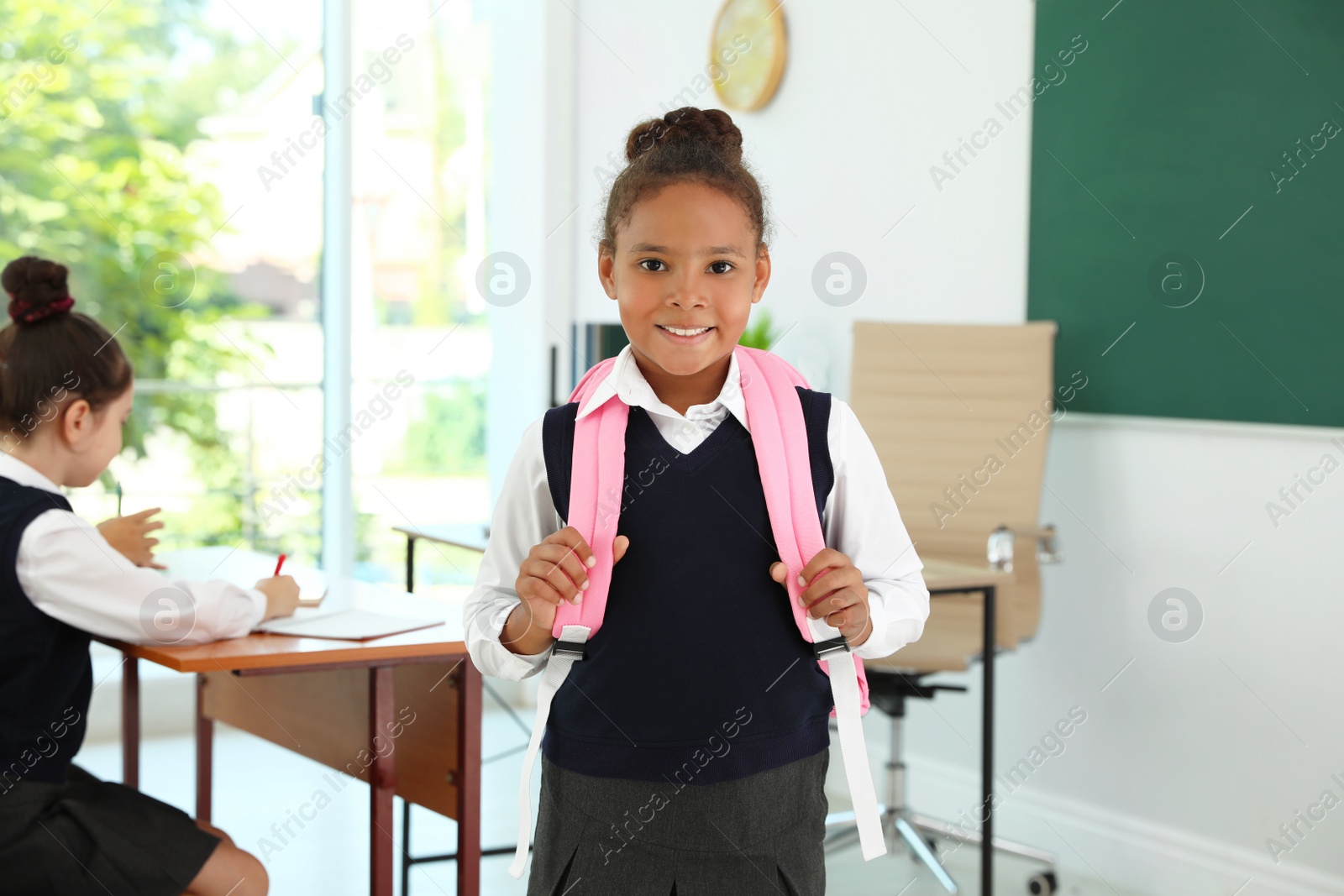 Photo of African-American girl wearing school uniform in classroom