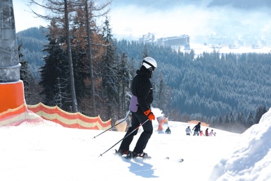 Photo of Man skiing on snowy hill in mountains. Winter vacation