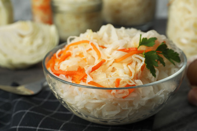 Tasty fermented cabbage with carrot on table, closeup