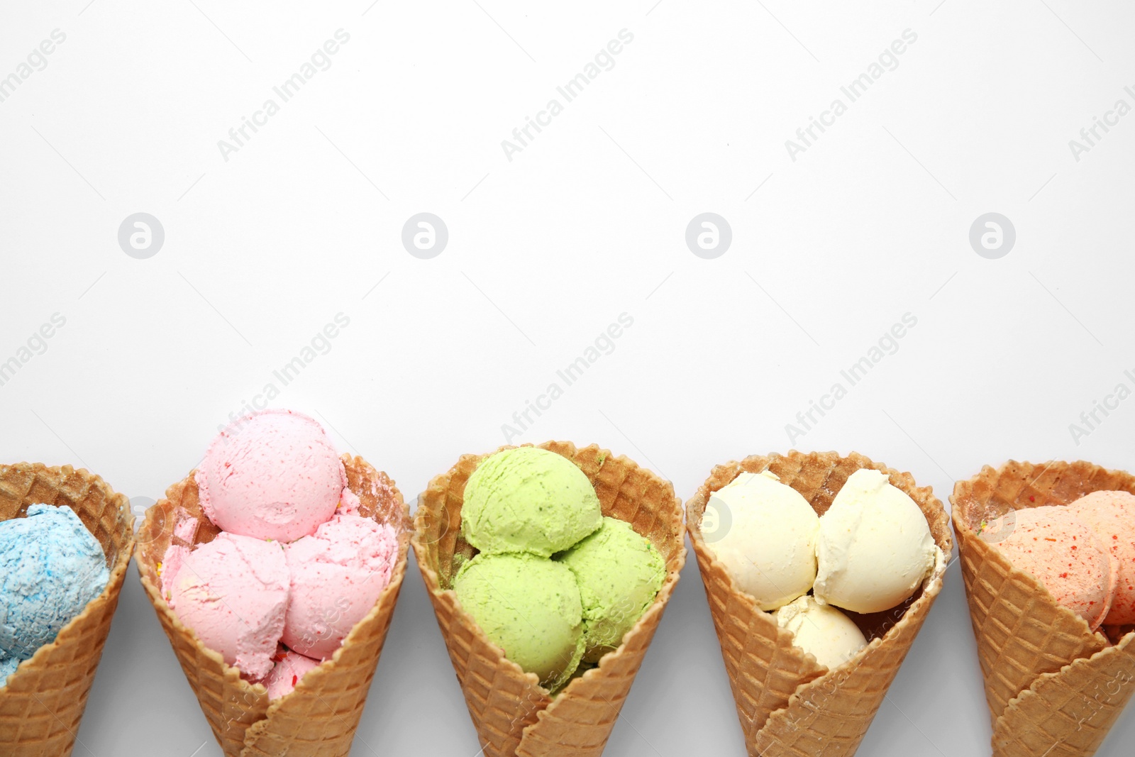 Photo of Composition with delicious ice creams in waffle cones on white background, top view