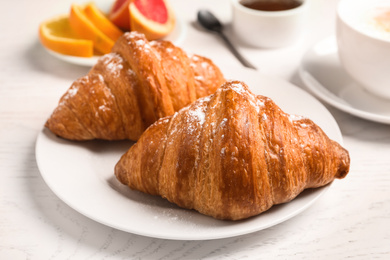 Photo of Tasty fresh croissants on white wooden table. Healthy breakfast