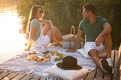 Happy couple spending time on pier at picnic