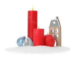 Beautiful burning candles with Christmas decor on white background