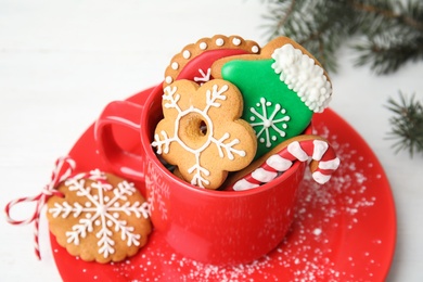 Photo of Cup with tasty homemade Christmas cookies on table