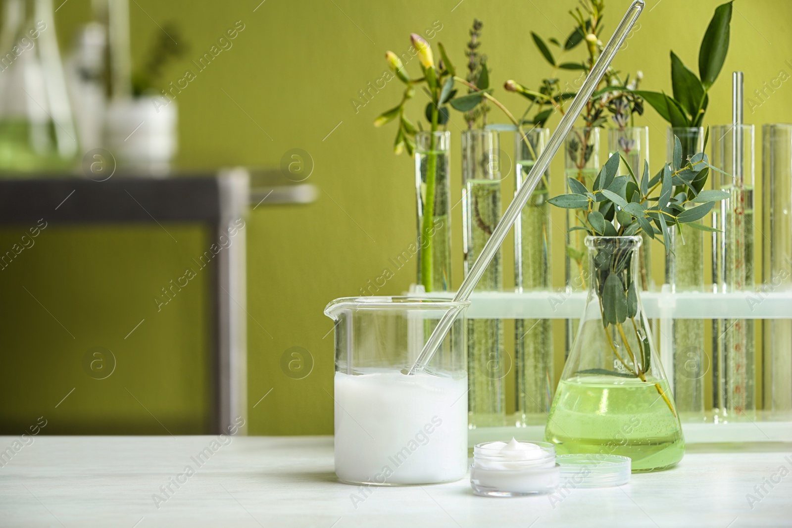 Photo of Cream and natural ingredients on white table in cosmetic laboratory