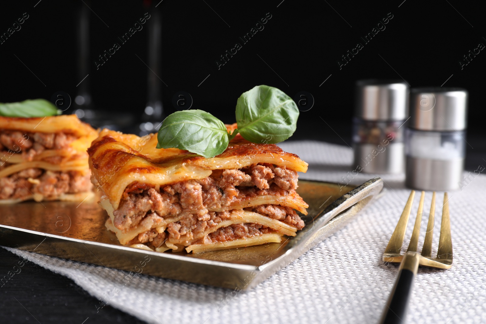 Photo of Delicious cooked lasagna served on black table