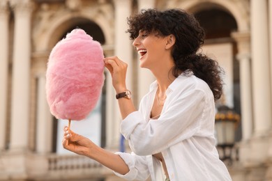 Beautiful woman with cotton candy on city street