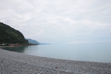 Picturesque view of sea coast and pebble beach. Space for text