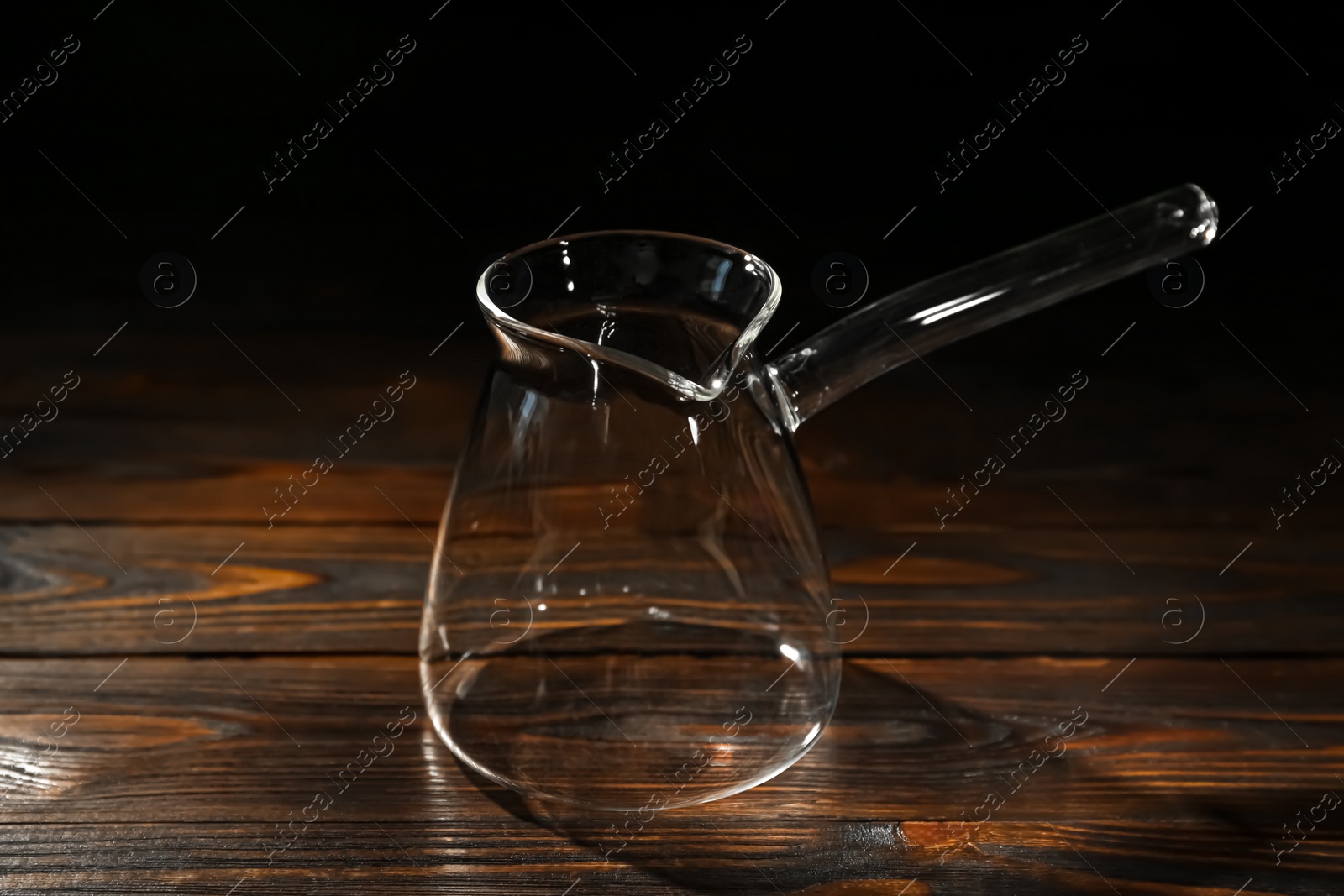 Photo of Empty glass turkish coffee pot on wooden table