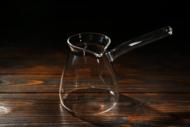 Photo of Empty glass turkish coffee pot on wooden table