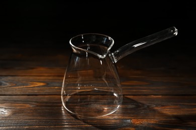 Empty glass turkish coffee pot on wooden table