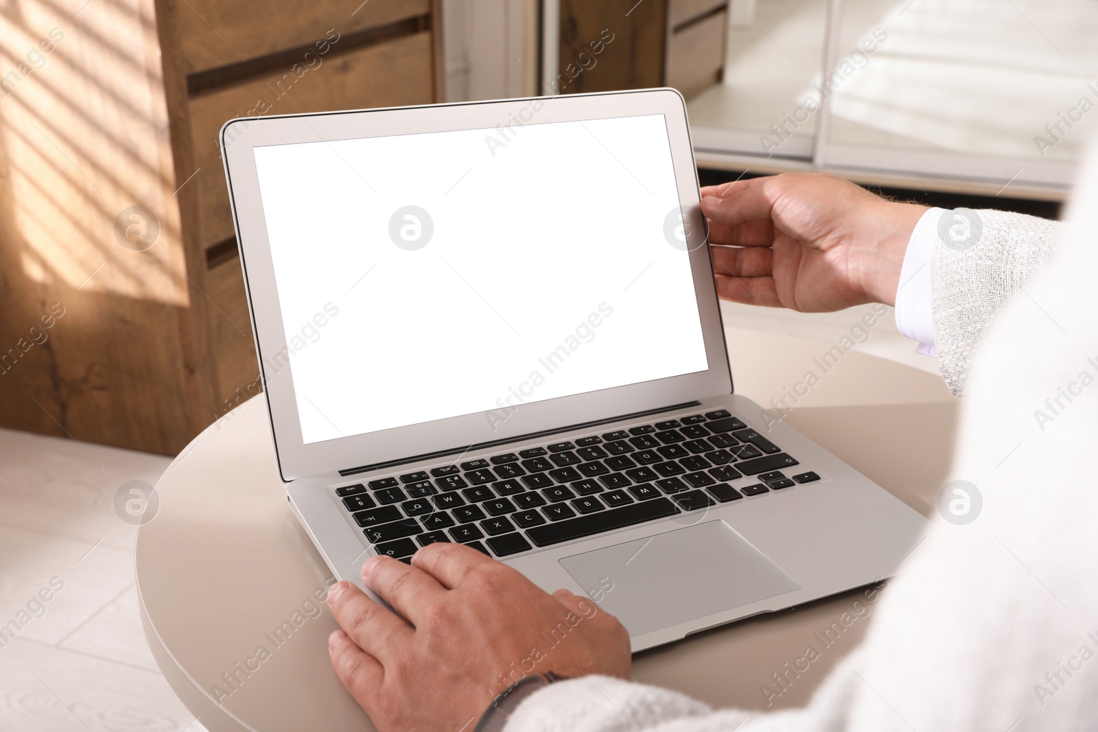 Photo of Businessman with modern laptop at table indoors, closeup. Space for design