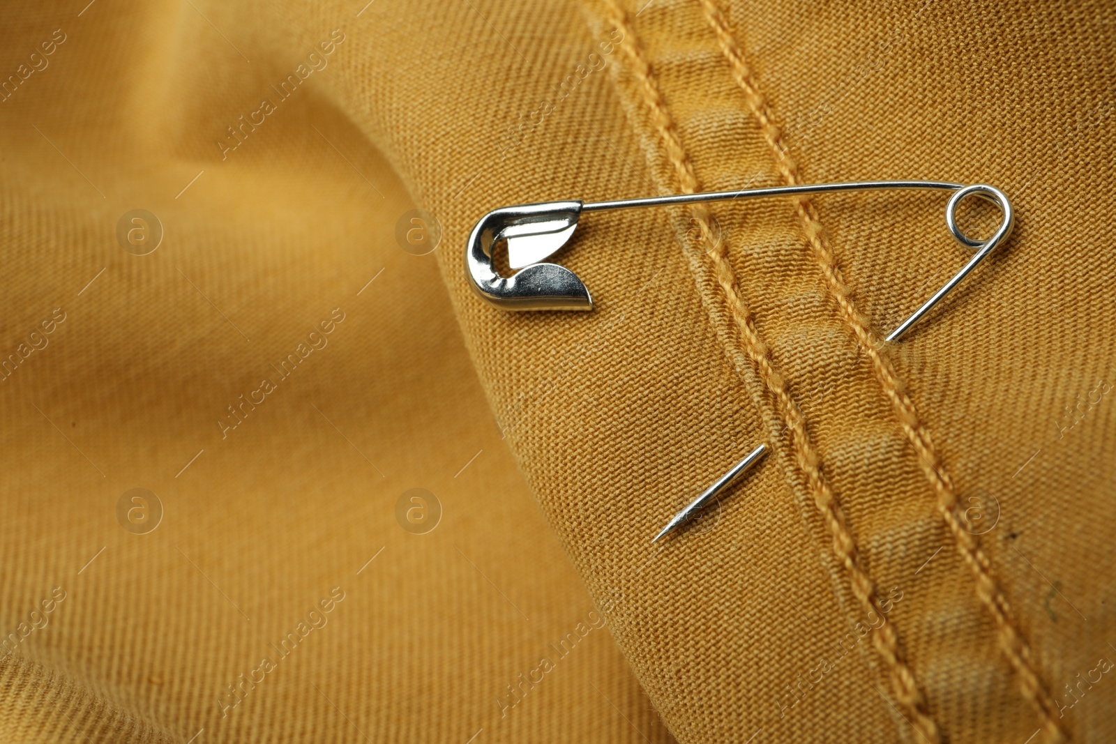 Photo of Closeup view of metal safety pin on clothing