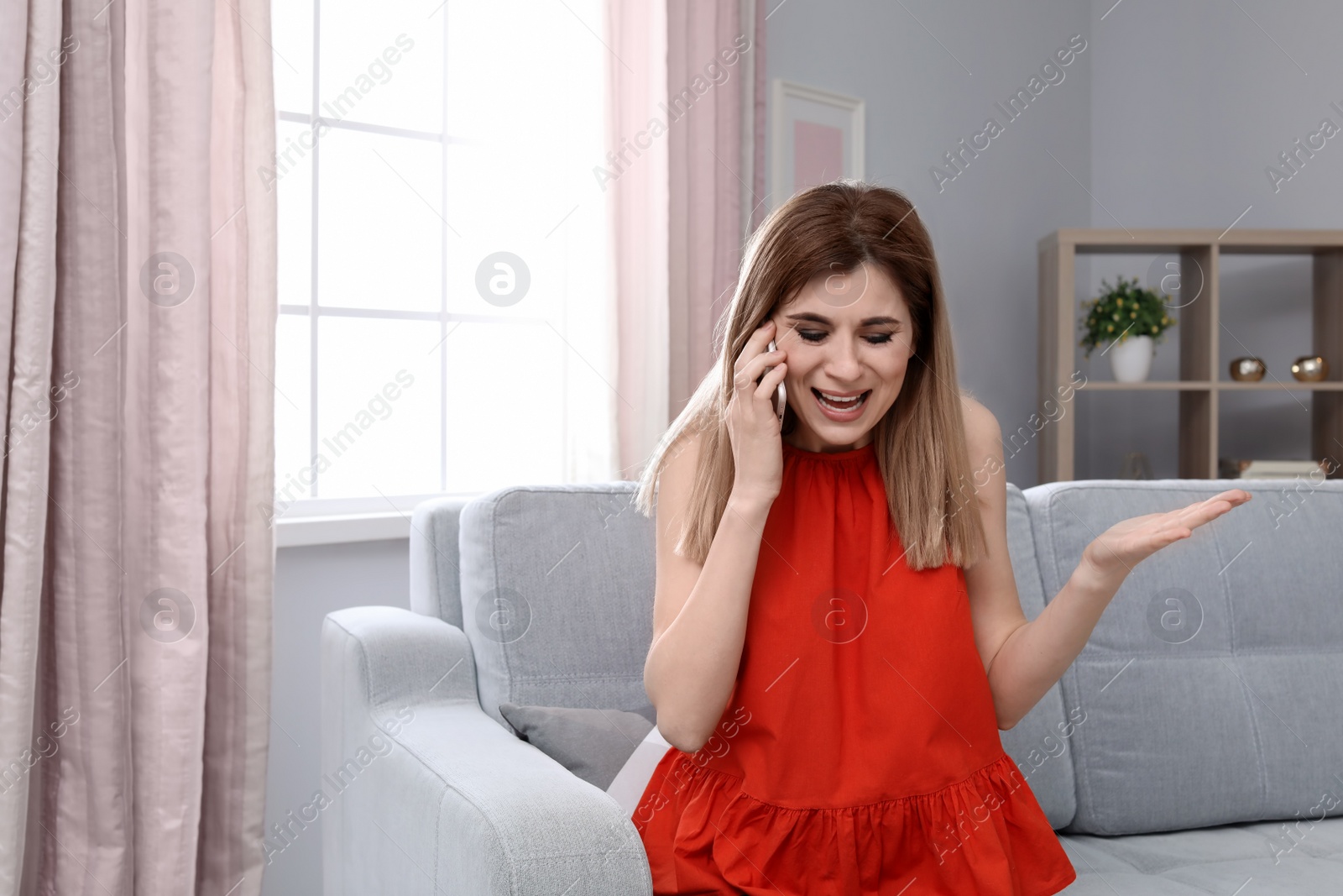 Photo of Woman arguing on mobile phone at home