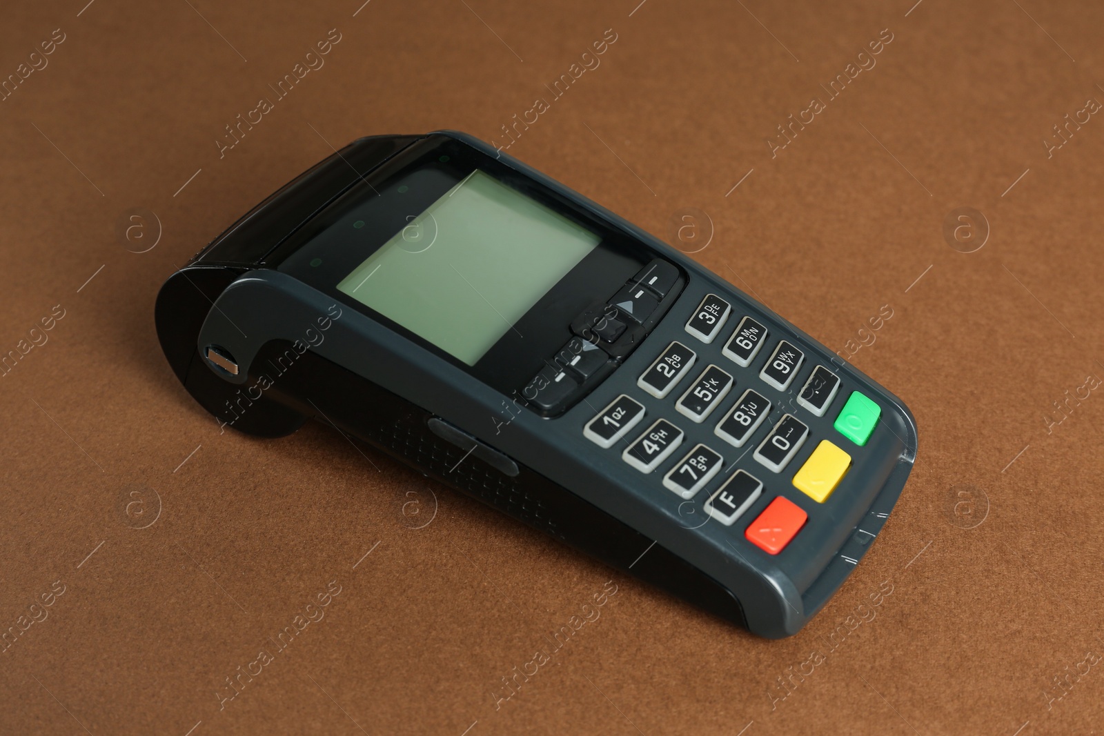 Photo of New modern payment terminal on brown background