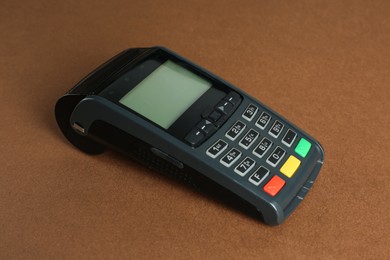 New modern payment terminal on brown background