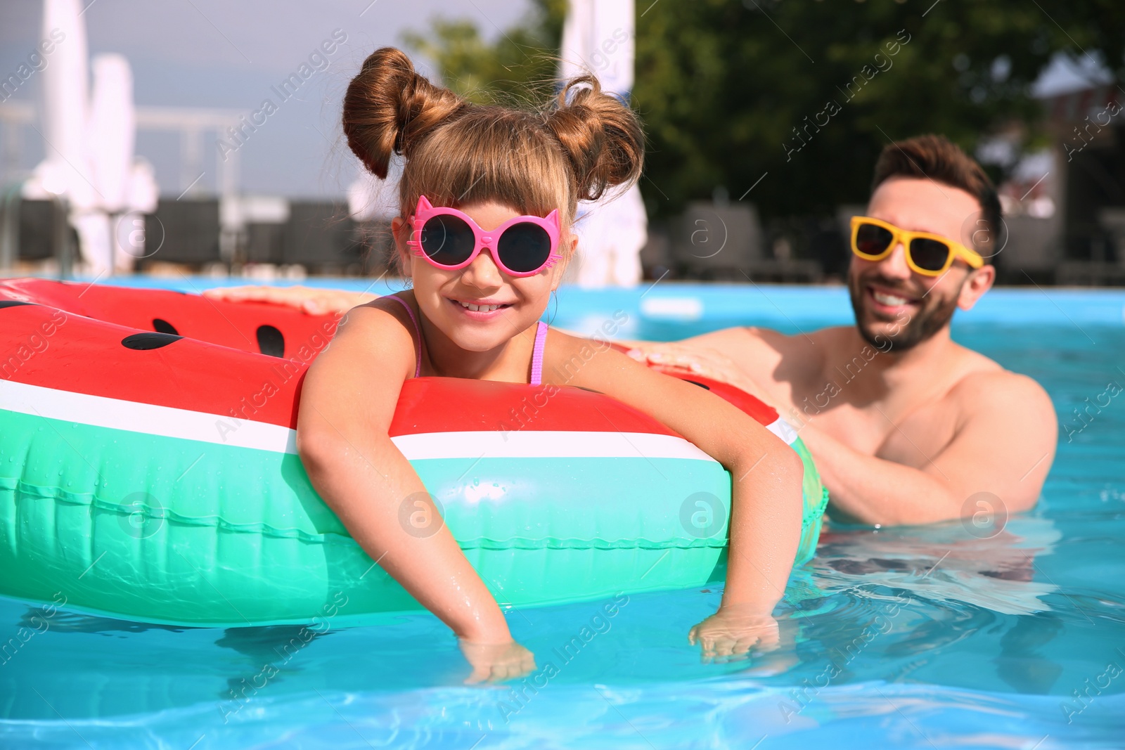 Photo of Father and daughter having fun in swimming pool. Family vacation
