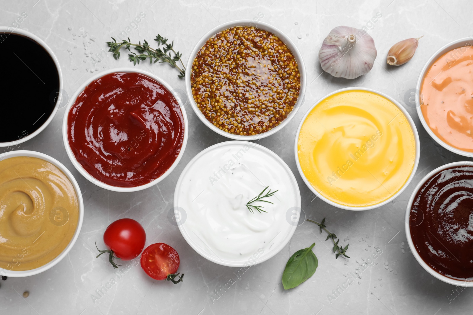 Photo of Many different sauces on light grey table, flat lay