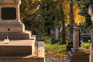 Photo of View of cemetery with granite tombstones on sunny day. Funeral ceremony