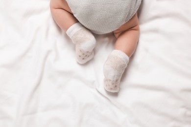 Photo of Newborn baby lying on blanket, top view. Space for text