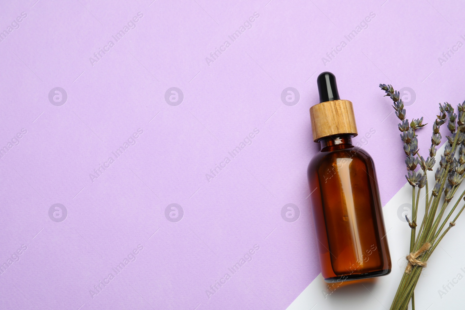 Photo of Bottle of face serum and beautiful flowers on color background, flat lay. Space for text