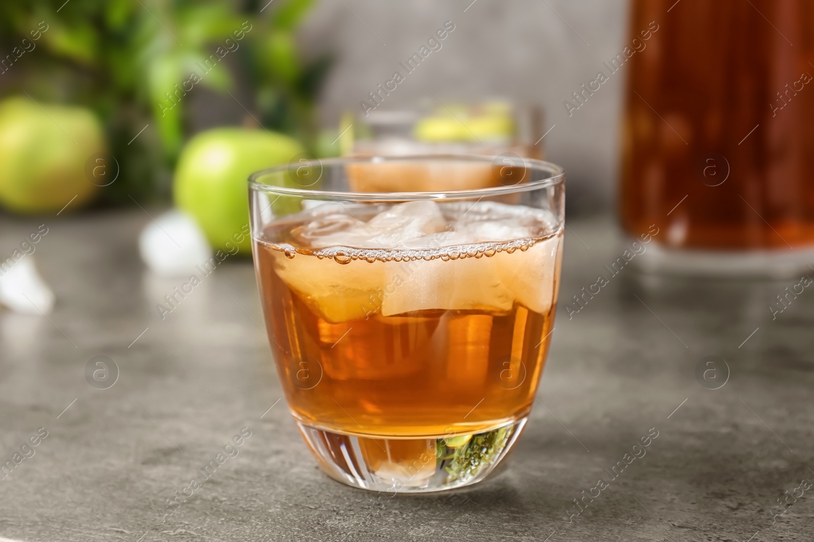 Photo of Glass of apple juice with ice cubes on table