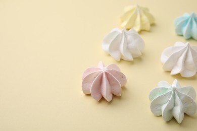 Photo of Delicious meringue cookies on beige background, closeup. Space for text